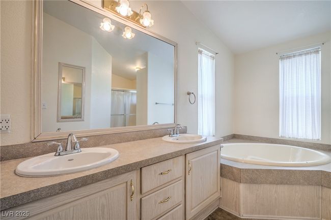 Full bath with double vanity, a garden tub, and vaulted ceiling | Image 18
