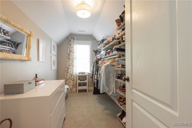 Walk in closet featuring visible vents, light colored carpet, and lofted ceiling | Image 36