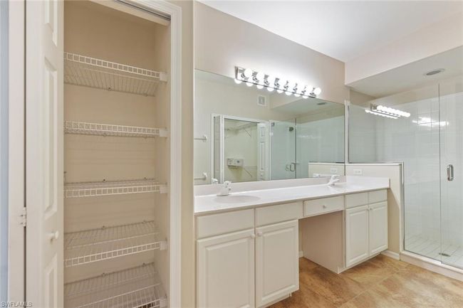 Bathroom featuring a spacious closet, double vanity, a sink, and a shower stall | Image 25