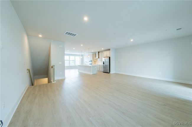 Unfurnished living room featuring recessed lighting, light wood-style flooring, baseboards, and a sink | Image 13