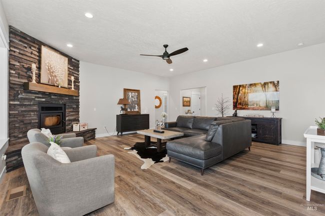 Living area with a fireplace, a ceiling fan, wood finished floors, and recessed lighting | Image 11