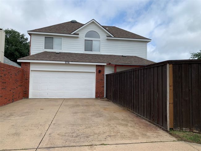 Traditional home featuring concrete driveway, a garage, roof with shingles, and brick siding | Image 12