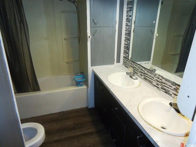 Full bathroom with wood finished floors, shower / tub combo, and double vanity | Image 12