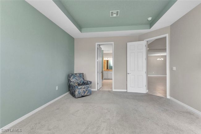 Master Bedroom with a tray ceiling, visible vents, baseboards, and carpet floors | Image 35