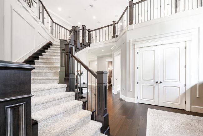Stairs with crown molding, a towering ceiling, wood finished floors, baseboards, and recessed lighting | Image 13