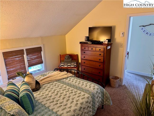 Spacious primary bedroom with his and hers closets. Feels very open with cathedral ceiling and natural light from windows. | Image 5