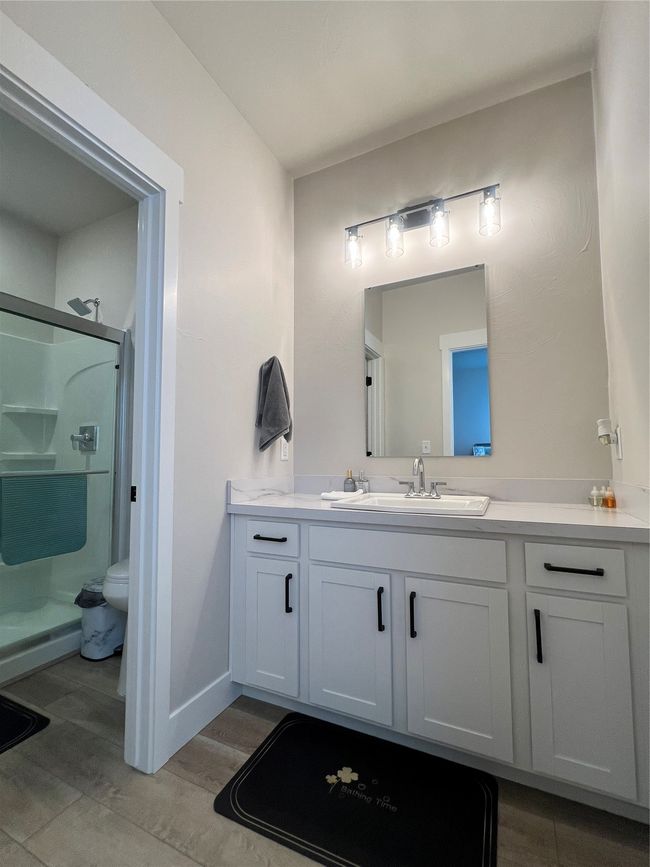 Full bath with vanity, a shower stall, toilet, wood finished floors, and baseboards | Image 15