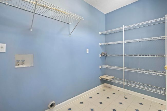 Laundry area featuring tile patterned flooring, hookup for an electric dryer, and hookup for a washing machine | Image 22