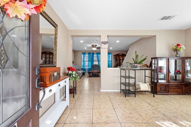 Tiled entrance foyer featuring baseboards, visible vents, ceiling fan, and recessed lighting | Image 7