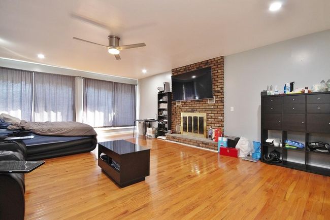 Family Room has a brick fireplace and hardwood floors | Image 14