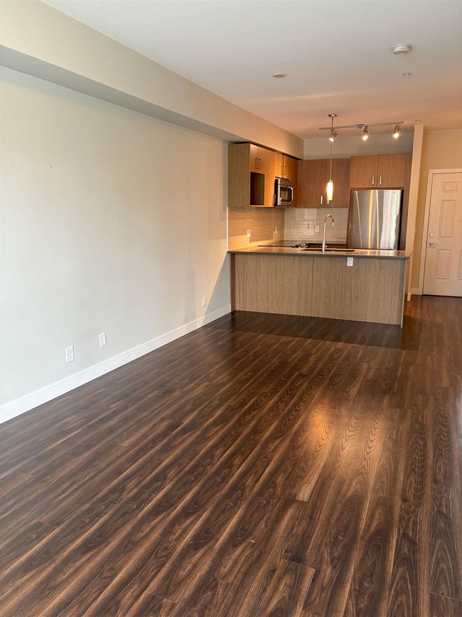 Unfurnished living room featuring a sink, baseboards, and dark wood finished floors | Image 8