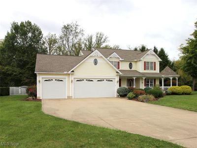 View of front of property with a front yard, a garage, and a porch | Image 1