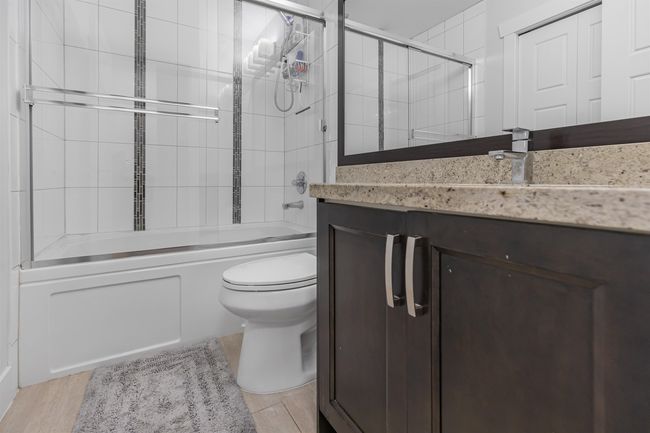 Above Main Bathroom with vanity, shower/bath combination with glass door, and wood finished floors | Image 14