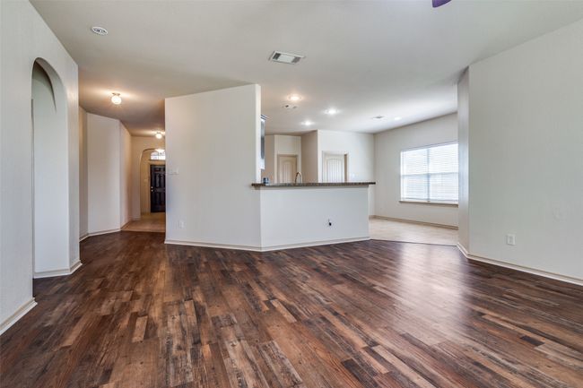 Unfurnished living room featuring arched walkways and wood finished floors | Image 8