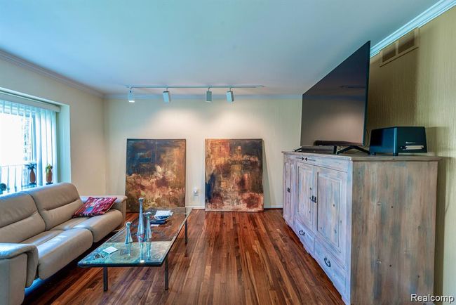 Living room featuring crown molding, dark wood-style floors, and track lighting | Image 19