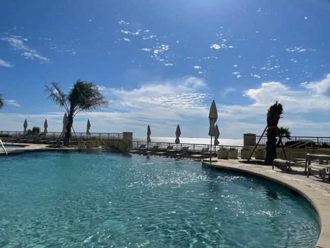 Enjoy year-round fitness and relaxation with a heated pool, perfect for water aerobics and swimming laps, set against a backdrop of clear skies and serene palm trees. | Image 31