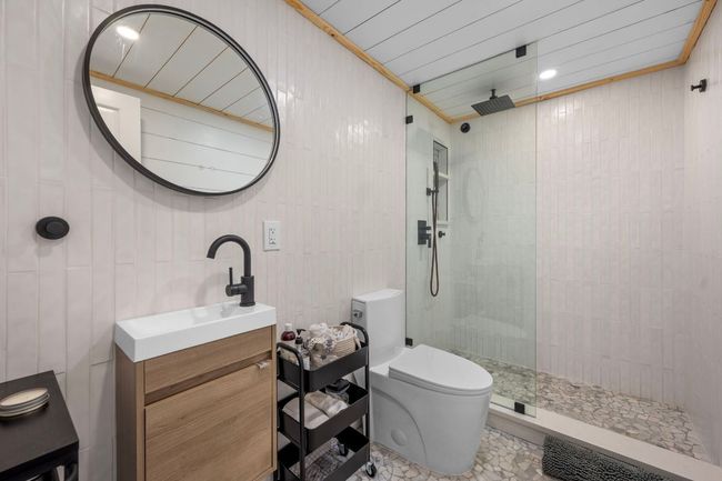 Bathroom featuring tile walls, toilet, walk in shower, and vanity | Image 14