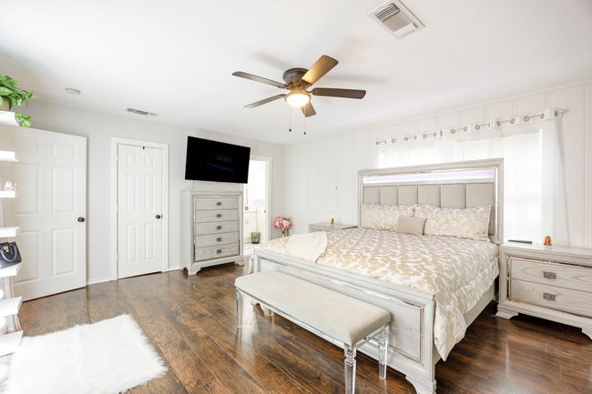 Bedroom featuring dark wood-style flooring, visible vents, and ceiling fan | Image 15