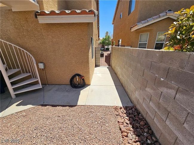 View of property exterior featuring stucco siding and a gate | Image 26