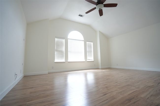 Master bedroom featuring light wood-type flooring, lofted ceiling, and ceiling fan | Image 11