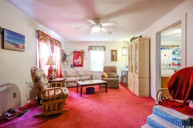 Carpeted living area with plenty of natural light and ceiling fan | Image 25