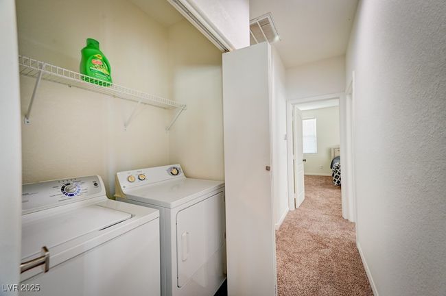 Laundry area featuring light carpet and washing machine and dryer | Image 15