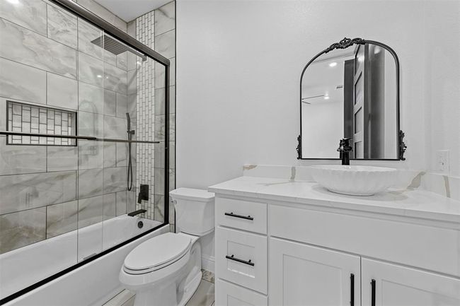 Full bathroom featuring enclosed tub / shower combo, toilet, and vanity | Image 30