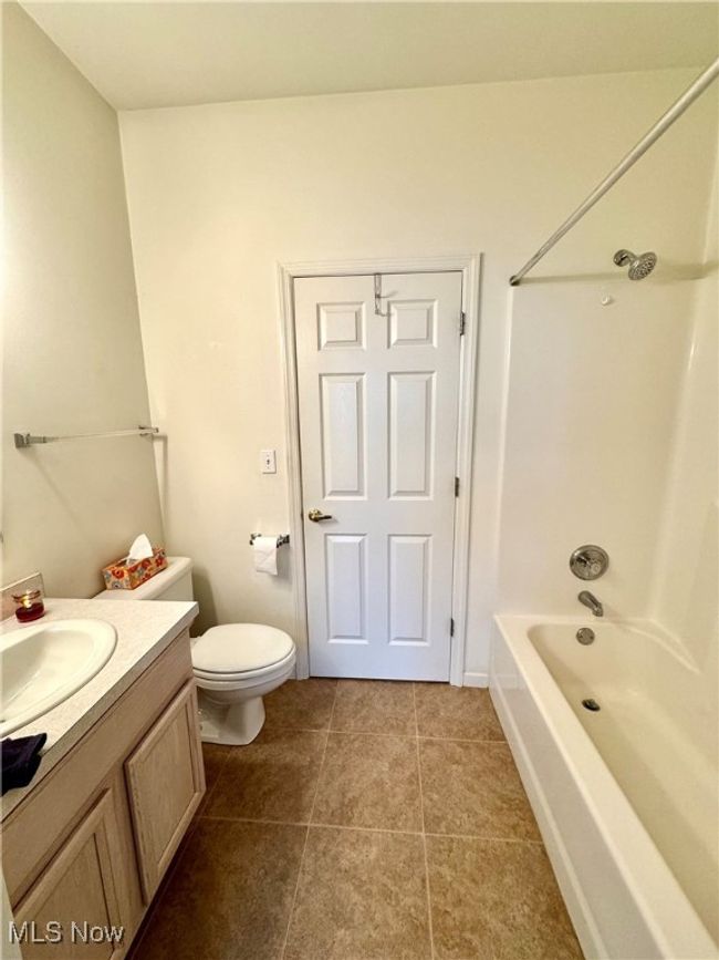 Full bathroom with tile patterned floors, vanity, toilet, and bathing tub / shower combination | Image 9
