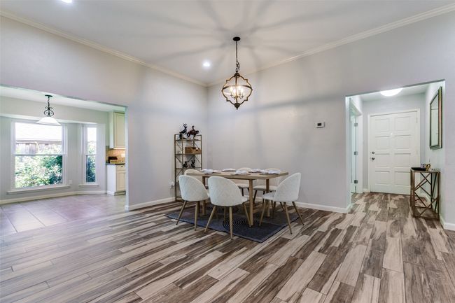 Dining area featuring wood finished floors, crown molding, recessed lighting, and a chandelier | Image 10