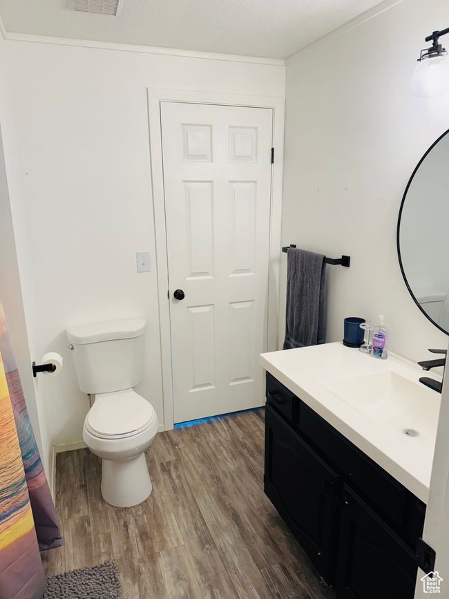 Bathroom featuring vanity, wood finished floors, toilet, and ornamental molding | Image 4