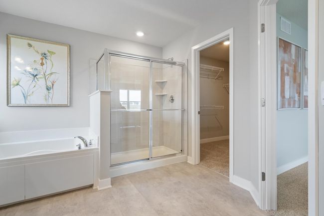 Primary bath with dual sinks, soaking tub, and separate shower. Model photo. Options and colors will vary. | Image 19