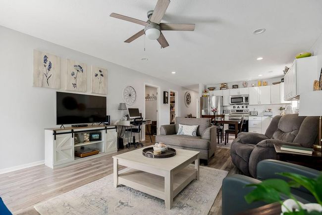 Living room with recessed lighting, light wood-style flooring, baseboards, and ceiling fan | Image 7