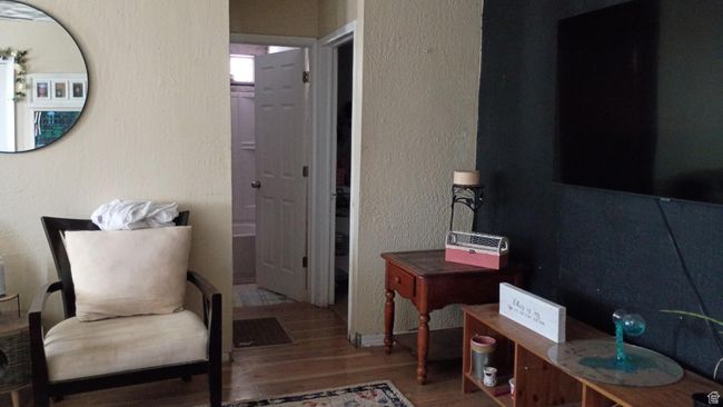 Living room featuring wood finished floors and a textured wall | Image 14