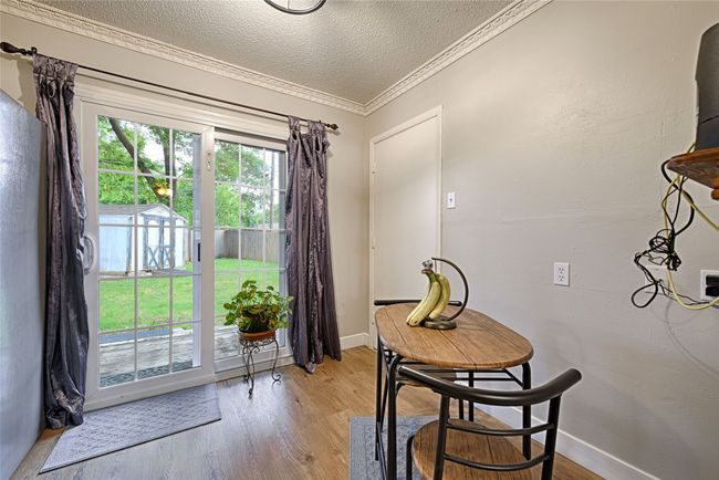 French sliding patio doors to back yard from the dining area with crown molding, updated lighting, and new floors | Image 10