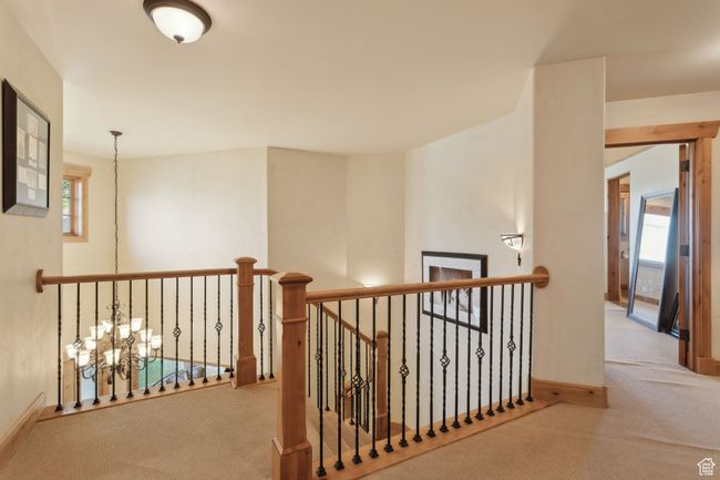 Hall with carpet, an upstairs landing, baseboards, and a chandelier | Image 22