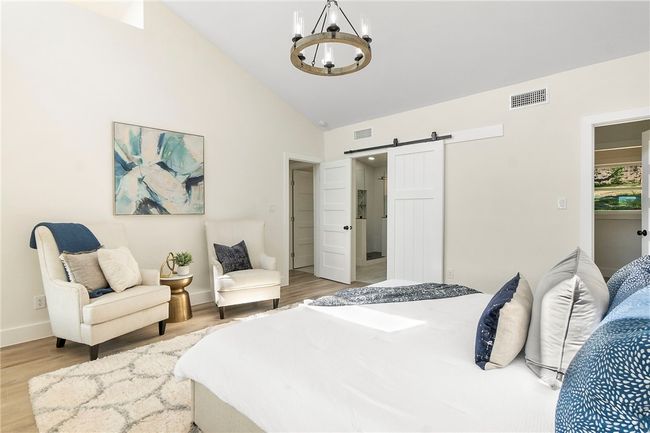 The primary bedroom also features a large walk-in closet and a sumptuous en-suite bath enclosed by a barn door. | Image 18