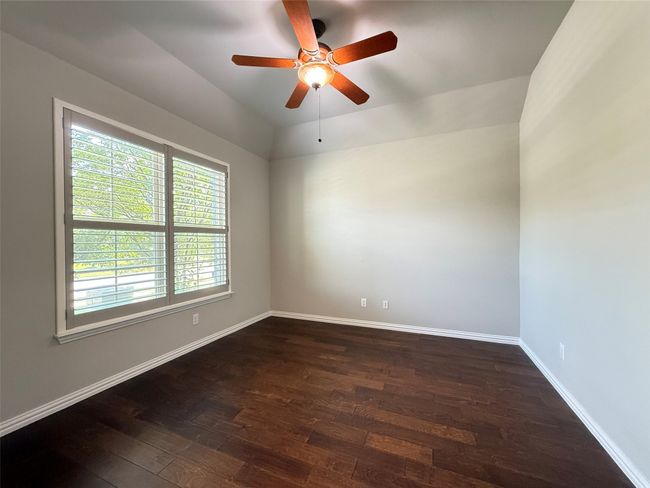 Unfurnished room with dark wood-style flooring, ceiling fan, and baseboards | Image 4