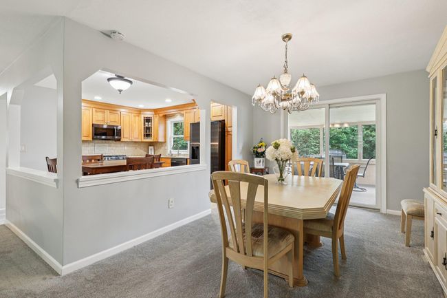 Dining room with carpet floors, a chandelier, and recessed lighting | Image 5
