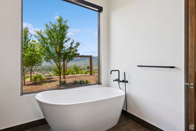 Full bathroom with a freestanding bath, baseboards, and wood finished floors | Image 85