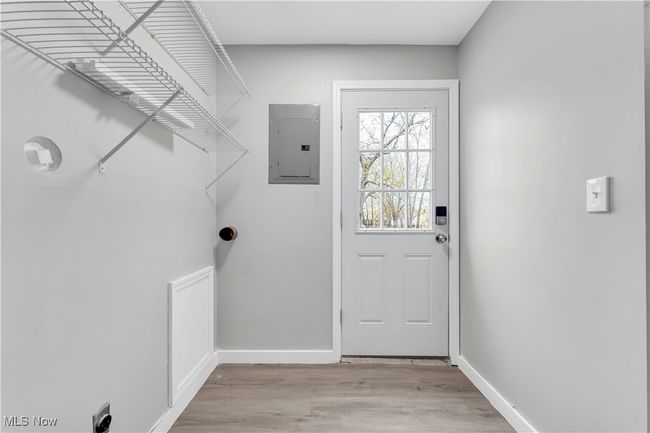Laundry area with baseboards, light wood-style floors, electric panel, and laundry area | Image 20