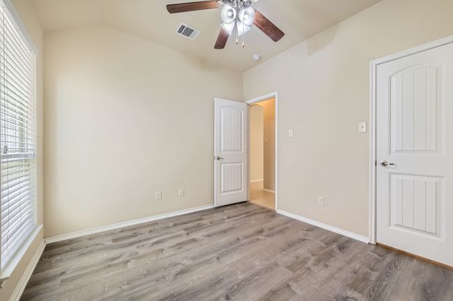 Unfurnished bedroom featuring light wood-style flooring, vaulted ceiling, and a ceiling fan | Image 23