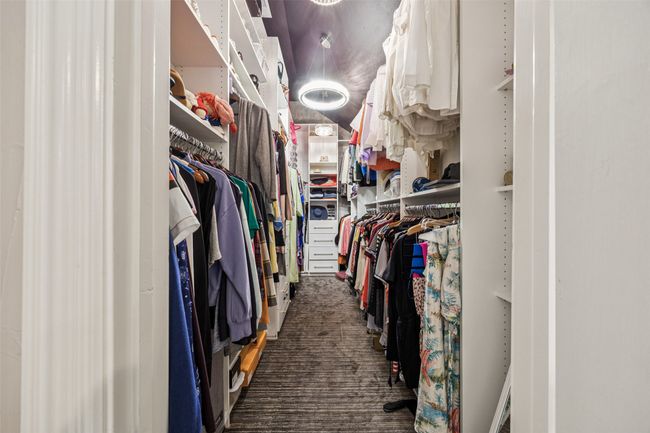 Walk in closet featuring dark carpet | Image 26
