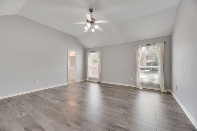 Unfurnished room with lofted ceiling, a ceiling fan, wood finished floors, and baseboards | Image 15
