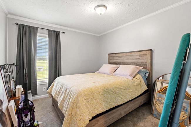 Bedroom featuring carpet floors, crown molding, and a textured ceiling | Image 24