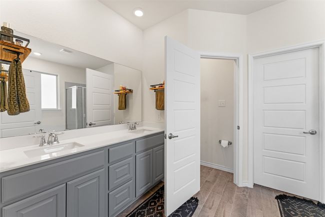Bathroom with a shower stall, double vanity, wood finished floors, and recessed lighting | Image 16