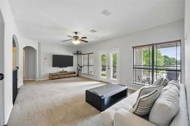 Enormous upstairs living/play/game room with lots of natural light and French doors to the covered balcony. | Image 24