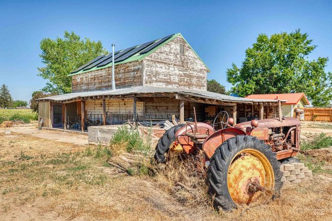 Back of property featuring an outbuilding, solar panels, and a metal roof | Image 43