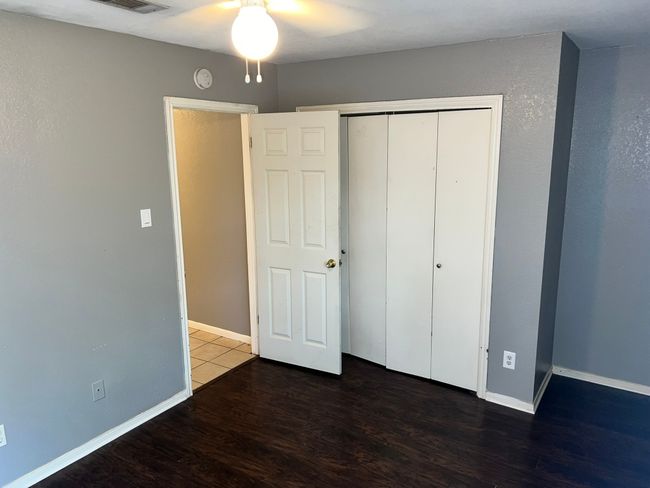 Unfurnished bedroom featuring wood finished floors, a closet, and a ceiling fan | Image 20