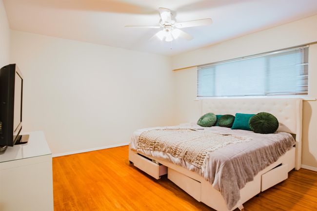 Bedroom with ceiling fan, baseboards, and light wood-type flooring | Image 18
