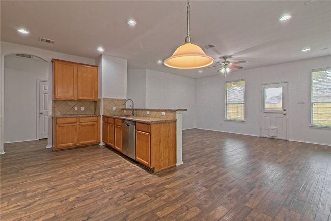 Kitchen featuring a peninsula, dishwasher, dark wood-type flooring, arched walkways, and recessed lighting | Image 12